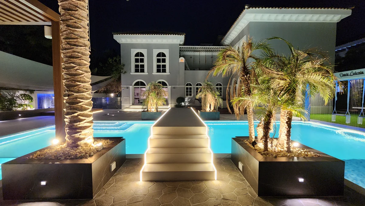 Project Casa Colonia after dark with illuminated pool, planting and raised walkway