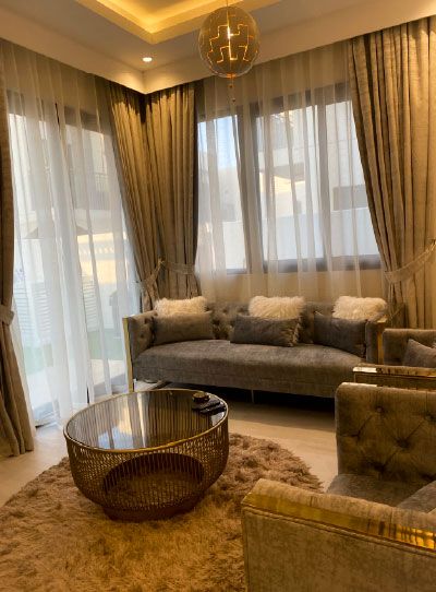Formal sitting room with sofas, a round glass table, long patterned curtains and a cove-lit gypsum ceiling, Project Alpha, DAMAC Hills 2