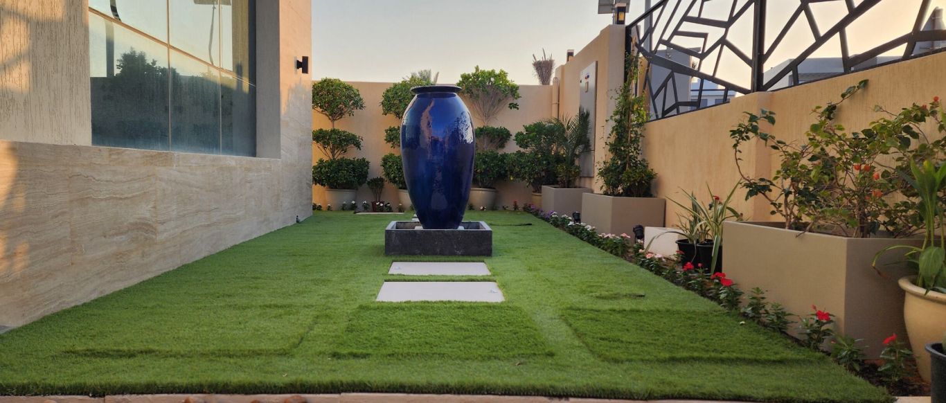 Lawn with stepping stones, planters and a large blue vase, Project Cliff, Al Furjan