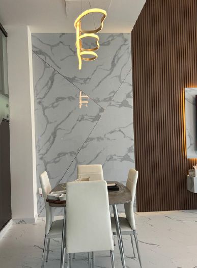 Dining area with a marble-look floor and feature wall under a sculptural light, Project Murano, Al Furjan